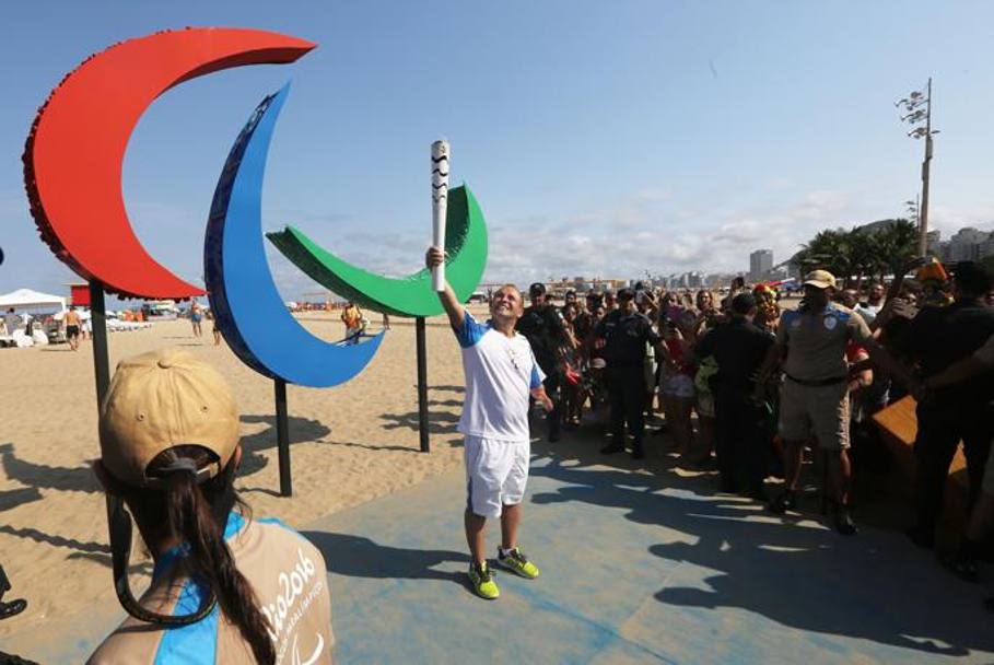 Un tedoforo davanti al simbolo della Paralimpiade. Getty